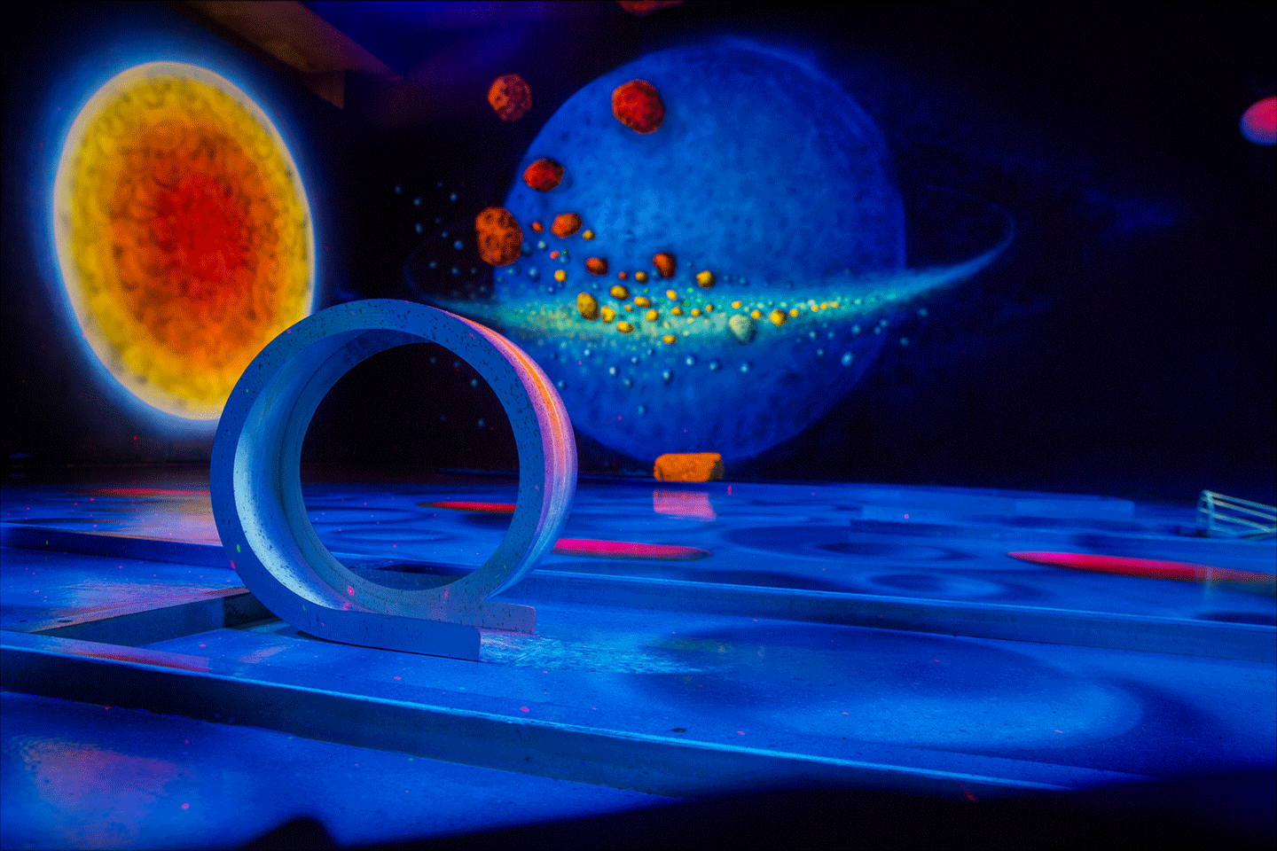 Weltraumkulisse auf einer Schwarzlicht-Minigolfbahn